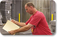 Employee putting file folders in bins for shredding